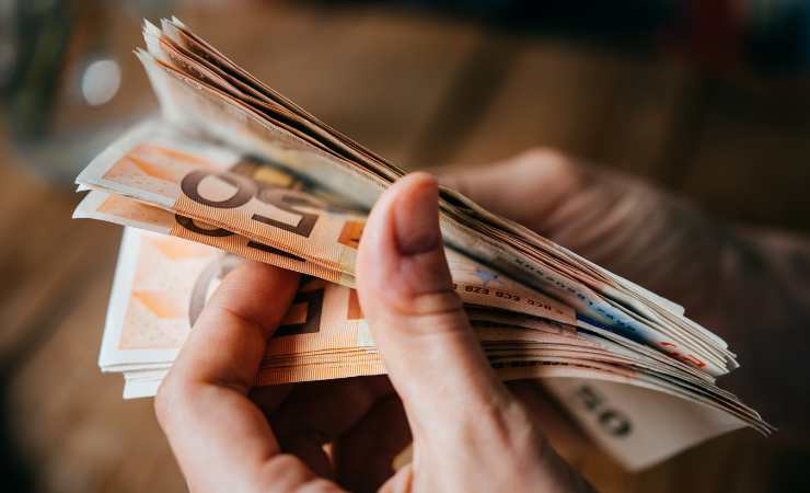 Mani che contano banconote in euro