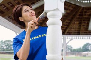 ragazza che sta per verniciare il gazebo in legno