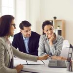 coppia che parla con donna che lavora al pc