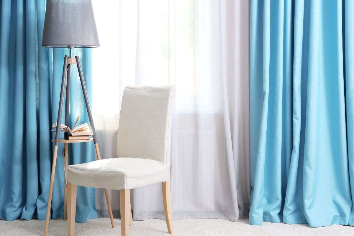 Tende salotto azzurre e sedia chiara