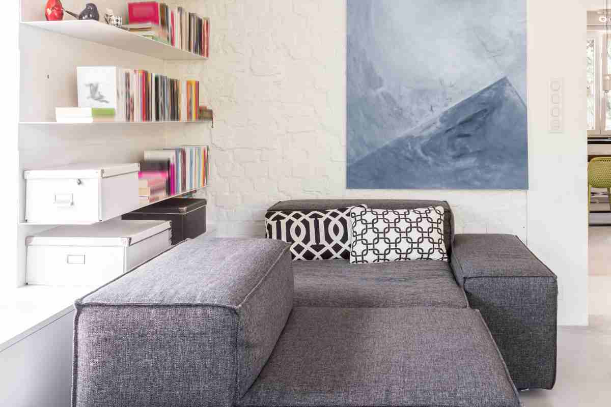 esempio di come arredare casa con il grigio con divano moderno, cuscini e quadri