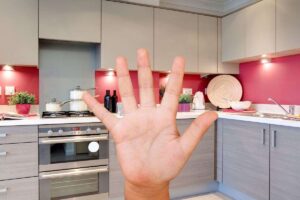 cucina in grigio e rosso con mano numero cinque
