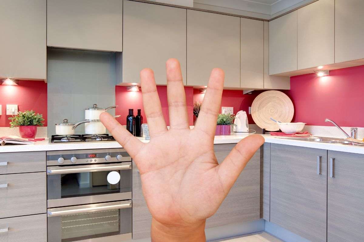 cucina in grigio e rosso con mano numero cinque