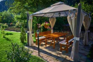 Gazebo con tende che ospita la zona pranzo con tavoli e sedie