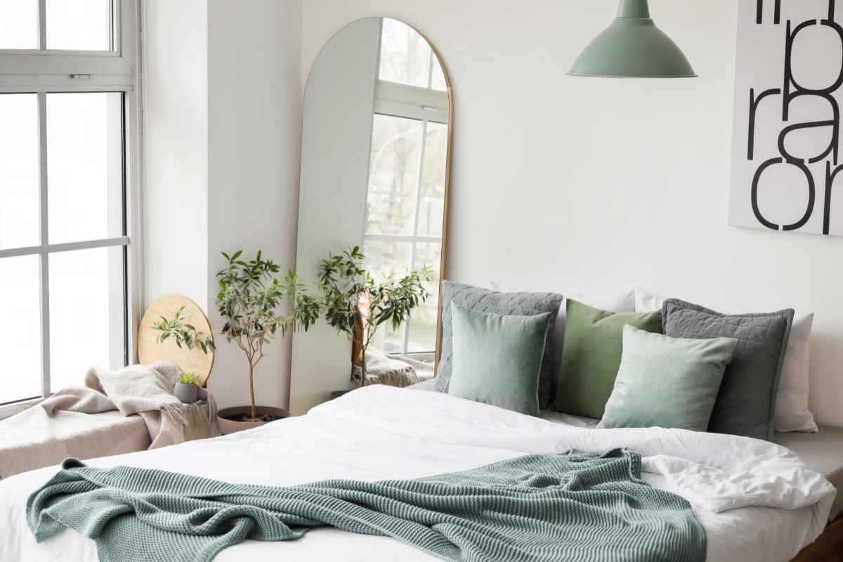camera da letto con specchio grande poggiato a terra