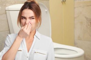 Cattivi odori bagno, donna si tappa il naso