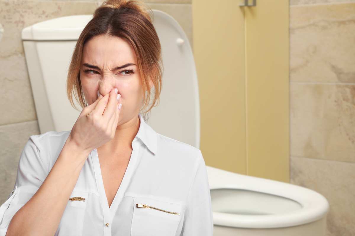 Cattivi odori bagno, donna si tappa il naso