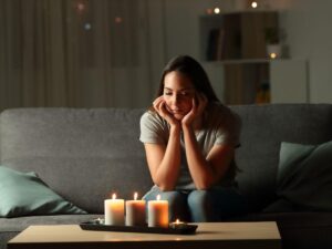 Donna che guarda candele in casa
