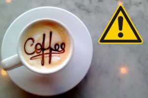 Tazzina del caffè e simbolo pericolo