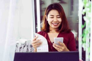 donna con cellulare e foglio in mano