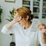 donna con bolletta in mano che si copre gli occhi