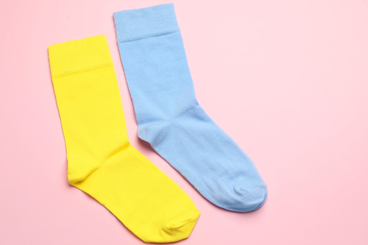 Calzino giallo ed azzurro su sfondo rosa chiaro