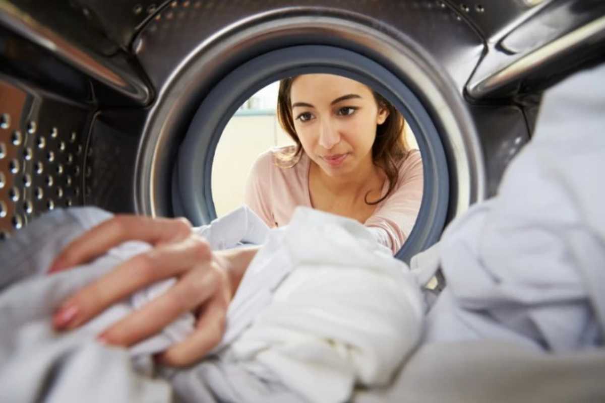 Donna fa il bucato in lavatrice