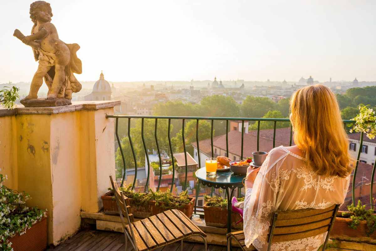 donna sul balcone che prende caffè