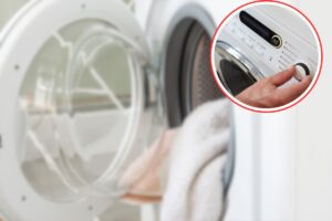 asciugamani in lavatrice con oblò aperto e donna che sceglie lavaggio nel cerchio
