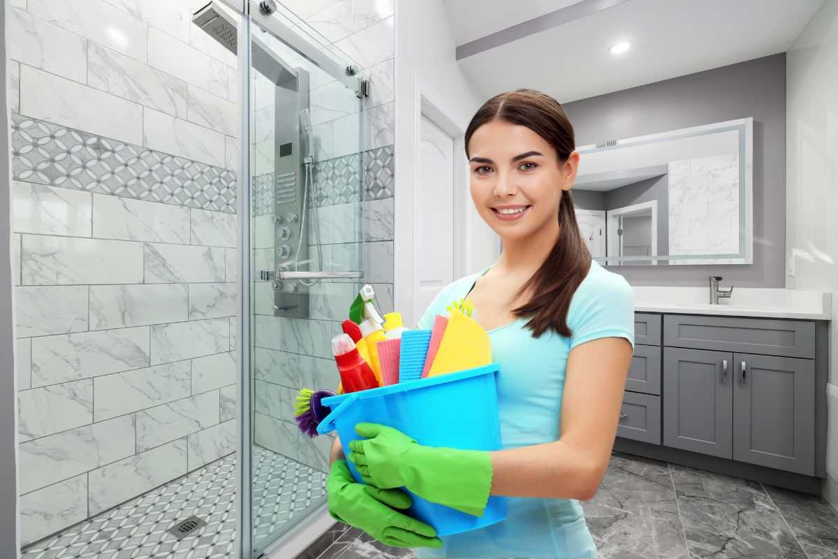 bagno sullo sfondo e donna delle pulizie sorridente