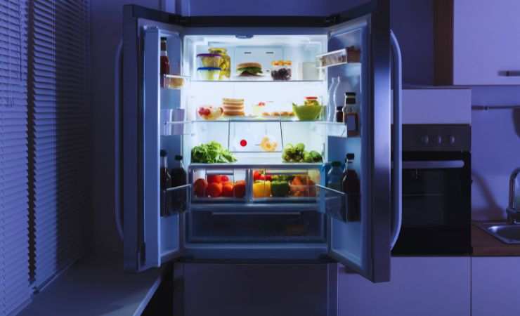 un frigorifero aperto con la luce della cucina spenta