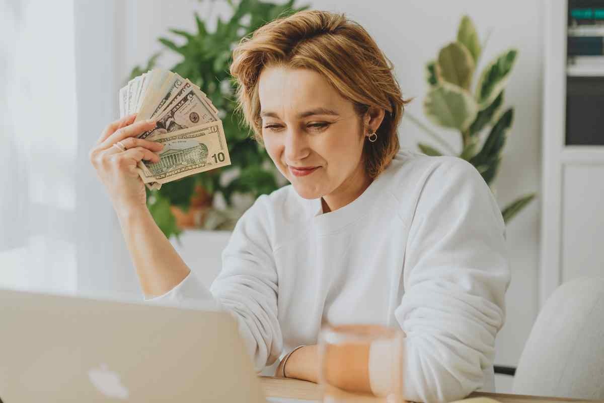 donna davanti al pc con soldi in mano