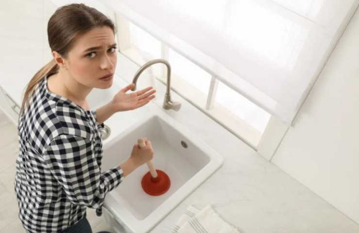 Donna cerca di liberare lo scarico