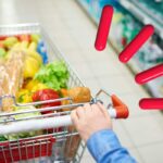Carrello pieno di spesa e simbolo attenzione