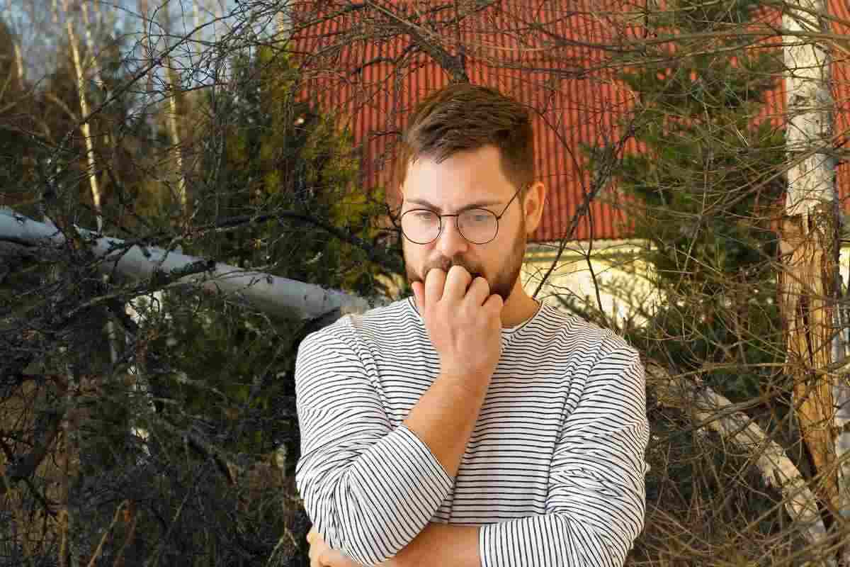 Uomo preoccupato e albero nello sfondo