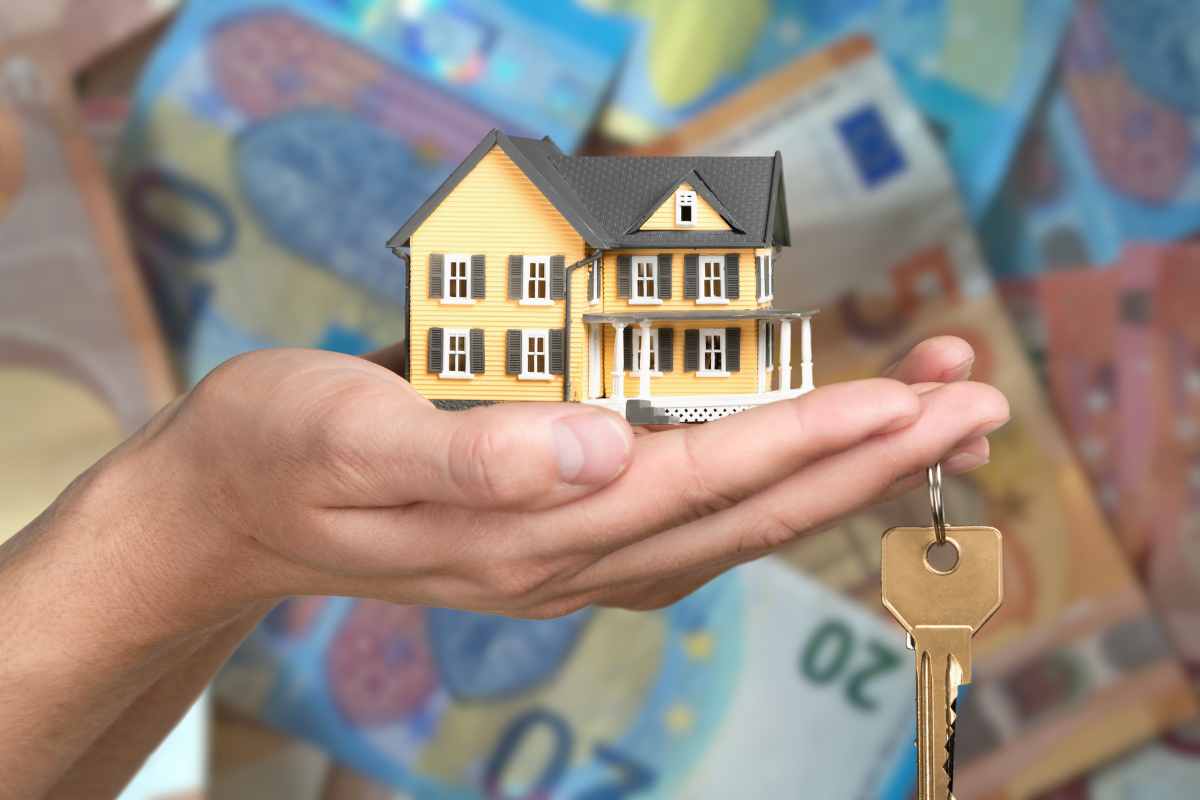 Mano con un modello di una casa