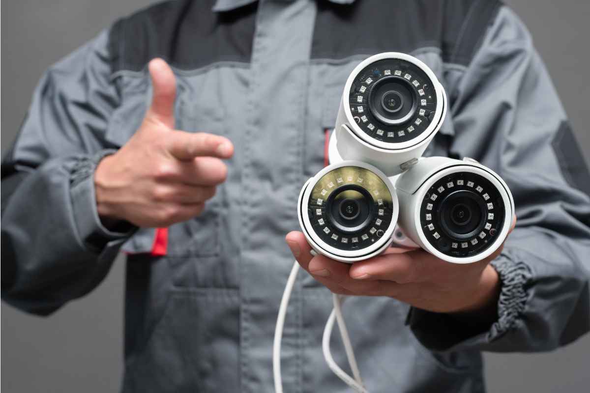 tecnico indica tre telecamere esterne che ha in mano