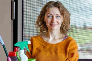 Donna con prodotti pulizia e zanzariera