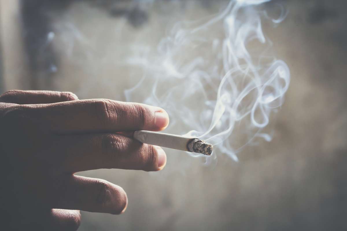 Mano con una sigaretta fumante