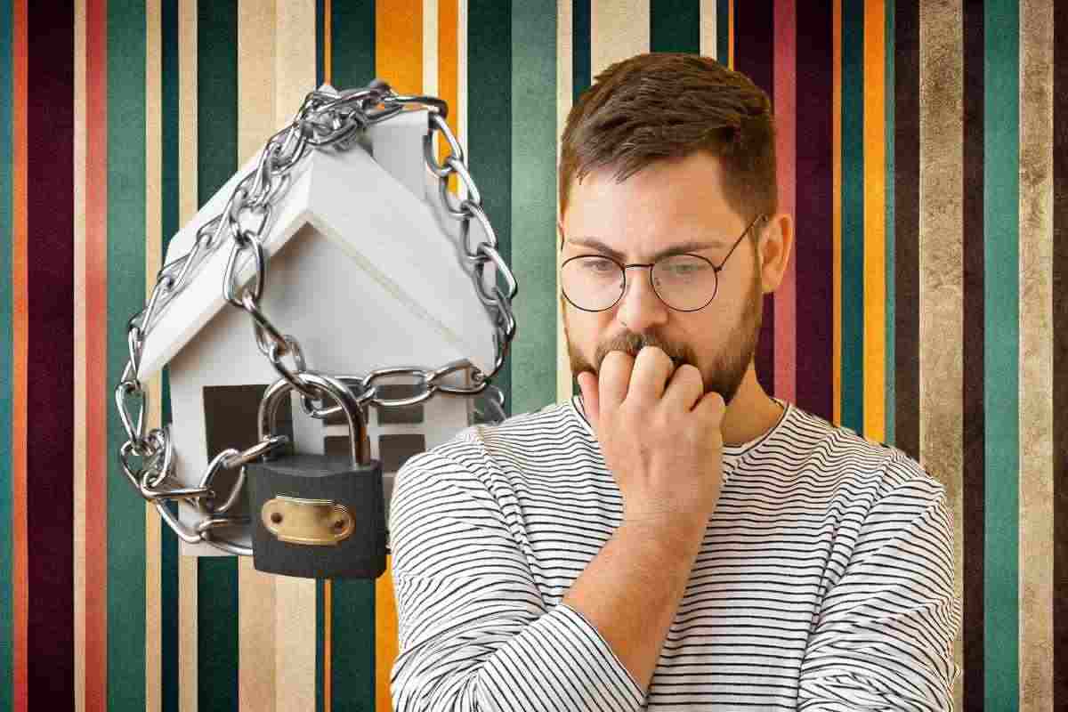Uomo preoccupato e casa con lucchetto