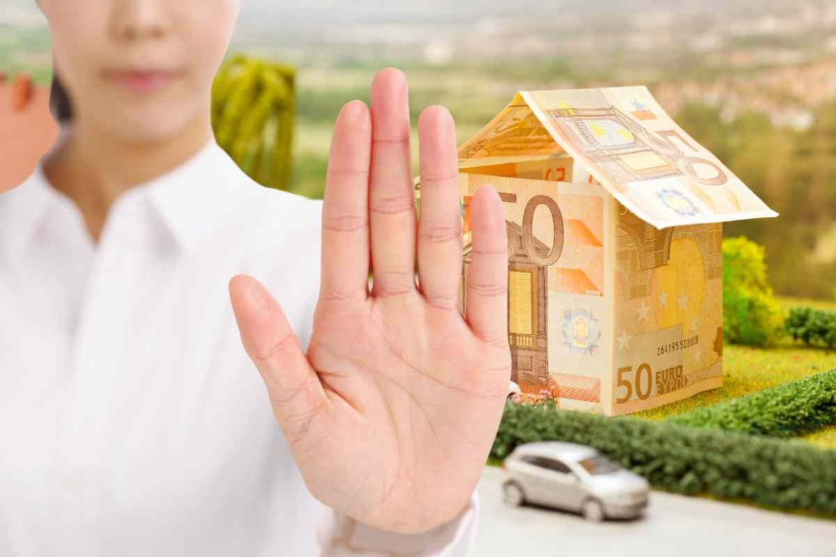 Alt con la mano e casa di soldi