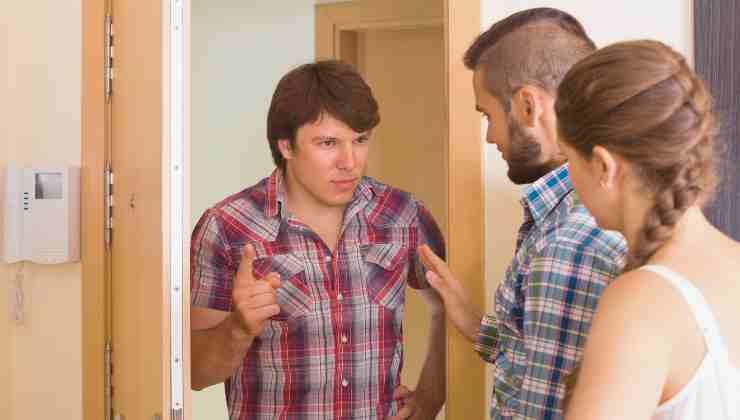 coppia di vicini discutono alla porta di casa