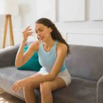 donna che si rinfresca con bicchiere ghiacciato