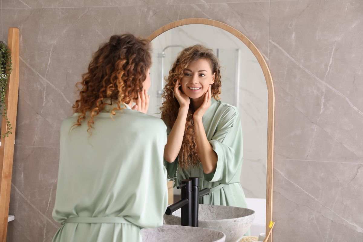 Donna allo specchio in bagno