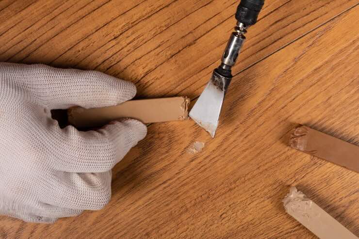 mano con pennello e cera per parquet 