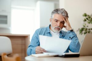 uomo che legge foglio preoccupato