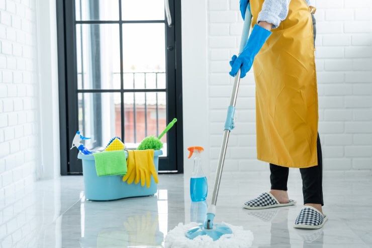 secchio con detersivo, persona che pulisce pavimento