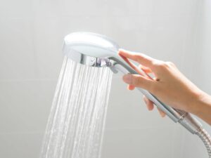 mano che tiene doccino con acqua che esce