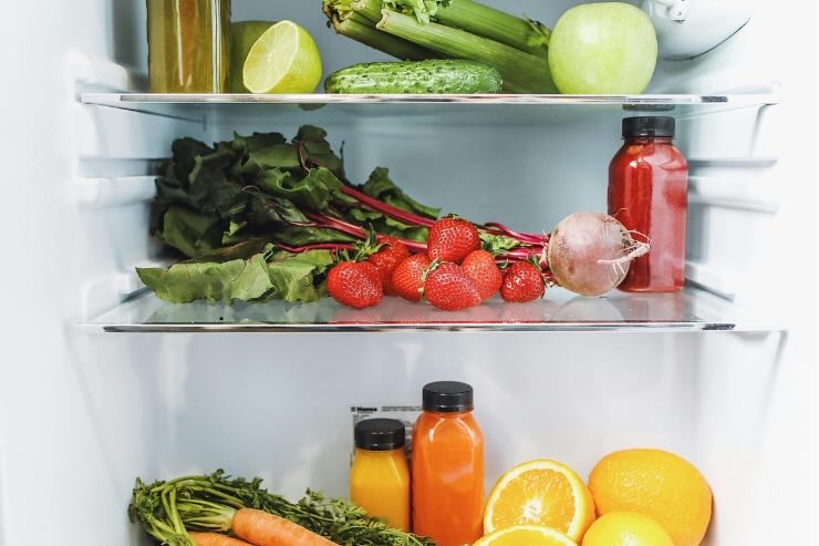 frutta, verdure, succhi nei ripiani del frigo