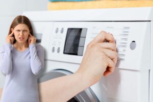 Accendere lavatrice, ragazza si tappa orecchie
