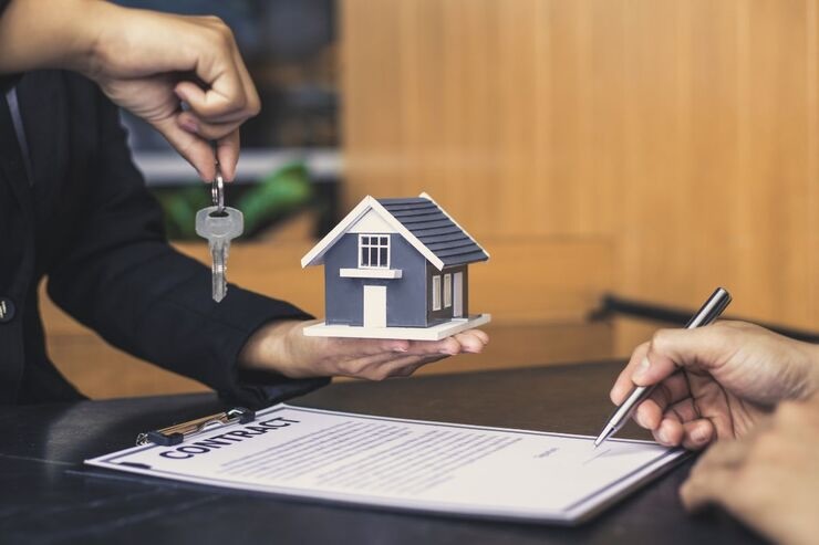 Firma di un contratto, riproduzione casetta e chiavi