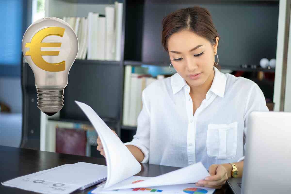 Donna controlla documenti e lampadina