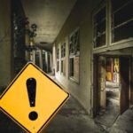 sfondo muri casa vecchia e cartello giallo con punto esclamativo