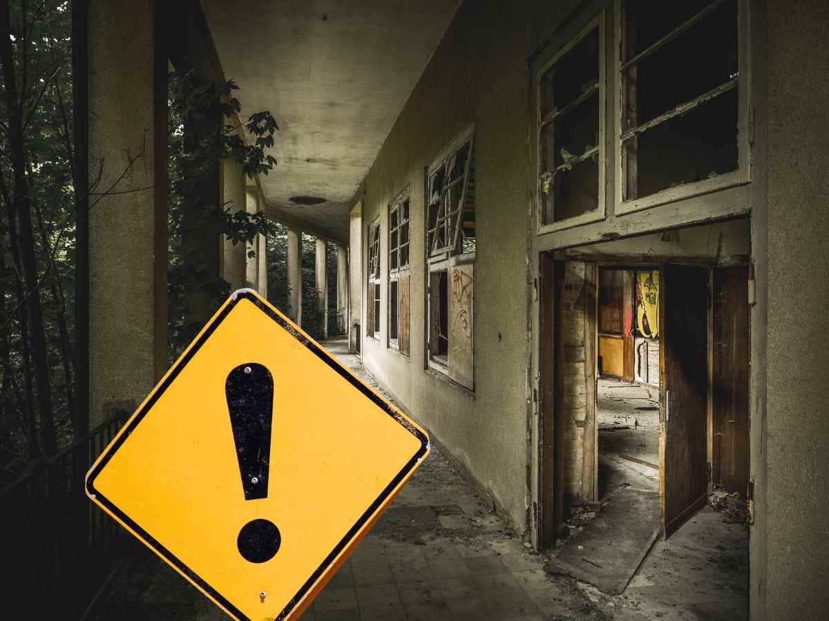 sfondo muri casa vecchia e cartello giallo con punto esclamativo