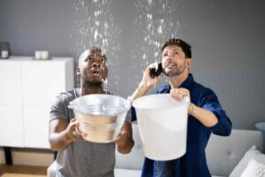 Persone con secchio e acqua dal soffitto
