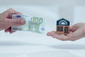 mano con soldi e altra con casa