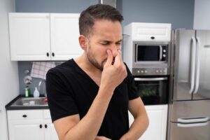 uomo che si tappa naso in casa