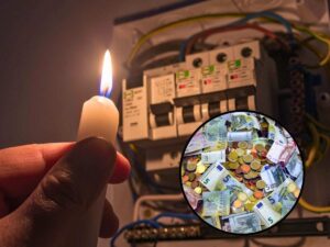 sfondo contatore al buio con mano con candela accesa e tondo con banconote e monete euro
