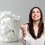 Cesta con bucato bianco, donna felice esulta