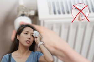x rossa su condizionatore, donna accaldata e un'altra che maneggia il termosifone